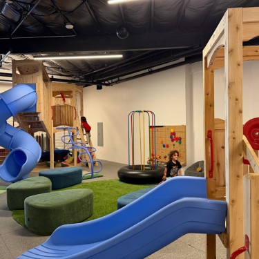 Indoor playground for kids featuring blue slides, climbing structures, and interactive play areas in Marin County.