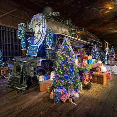 Steam locomotive with Christmas Trees and Polar Express sign at California State Railroad Museum