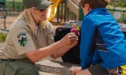Ranger and child making art at playground