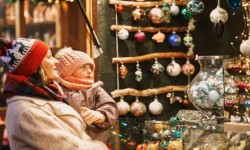 Mom and child looking at holiday crafts in an outdoor market