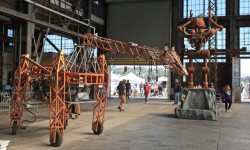 Maker Faire Bay Area robotic giraffe and robot inside big hangar like building