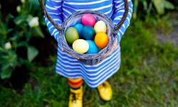 Little girl holiding easter eggs in a basket