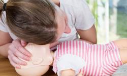 Infant CPR woman training with mannekin