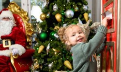 Small child and Santa in room with Christmas tree