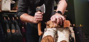 person with hatchet carving wood