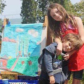 Two kids displaying their artwork