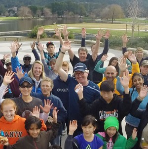 People cleaning up park on Earth Day waving hands