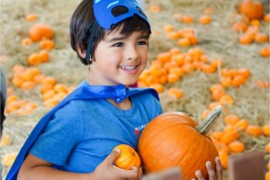 Harvest Fair boy in costume with pumpkins