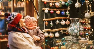 Mom and child looking at holiday crafts in an outdoor market