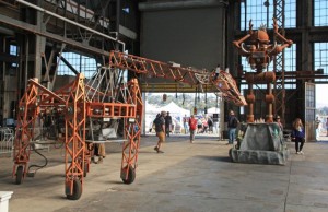 Maker Faire Bay Area robotic giraffe and robot inside big hangar like building