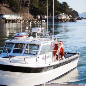 Santa on boat sailing into Nick's Cove on Tomales Bay