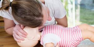 Infant CPR woman training with mannekin