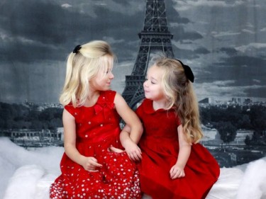 Little girls in dresses for holiday tea with Eiffel tower in background