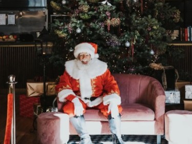 Santa sitting by Christmas tree