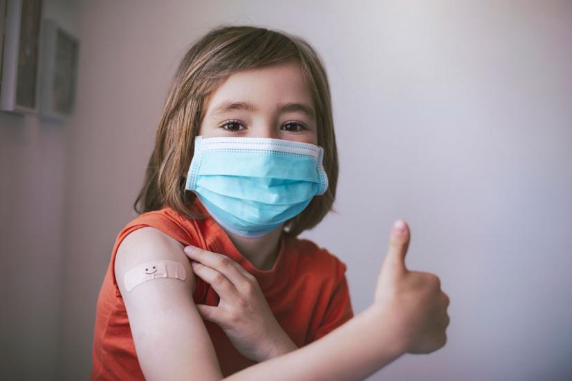 Little girl giving thumbs-up after COVID vaccine