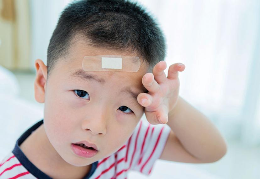 Young boy with band-aid on forehead