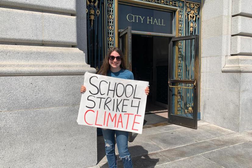 Sarah Goody with sign in front of city hall