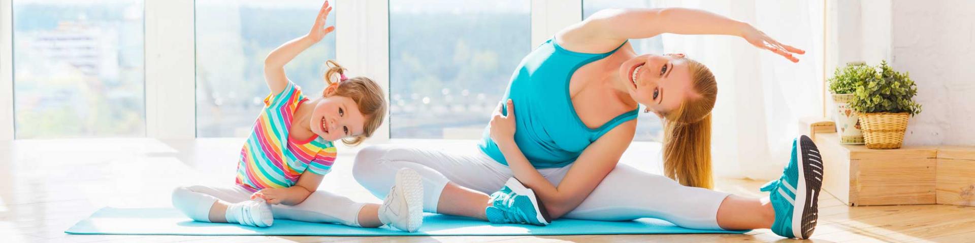 Mom and daughter doing yoga in a brightly lit room