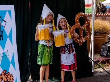 Girls posing with fake beer and pretzels Oktoberfest