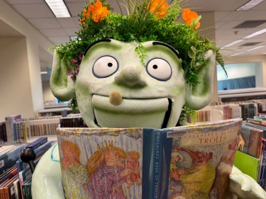 Wylding Woods troll puppet with book in library