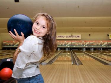 Child bowling at birthday party